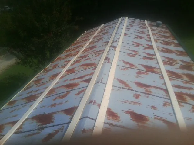 Rusted metal roof panels with new wood purlins before replacement — Storm Damage Roof Repair in Hamersville by Roofing Brothers
