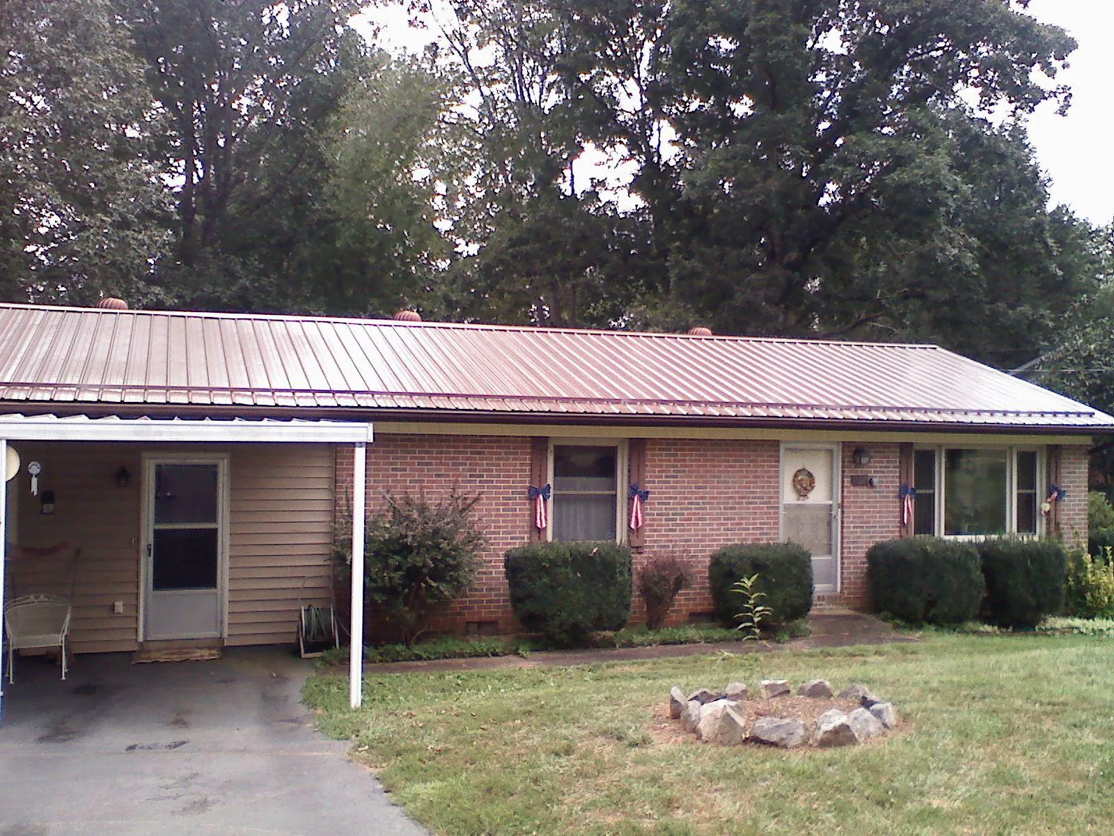 Bronze metal roof and carport on a brick ranch home — Roof Repair work by our crew in Hamersville
